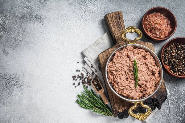 Uncooked vegan mince meat, raw plant based meat with thyme in skillet. White background. Top view. Copy space.