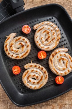 Baharatlı ızgara tavada kızartılmış et sosisi. Ahşap arka plan. Üst görünüm.