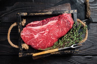 Kokainsiz biftek ya da çiğ sığır eti bifteği. Siyah ahşap arka plan. Üst görünüm.