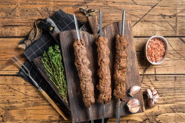 Kıymalı kuzu etinden yapılmış şiş ızgara Adana kebabı. Ahşap arka plan. Üst görünüm.