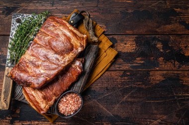 Meat restaurant kitchen. Smoked BBQ Pork Ribs on wooden cutting board. Wooden background. Top view. Copy space.