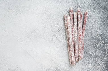 Traditional Spanish mini fuet sausage. White background. Top view. Copy space.