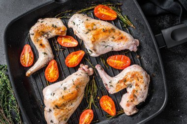 Tavada kekik ile kavrulmuş tavşan bacağı. Siyah arka plan. Üst görünüm.