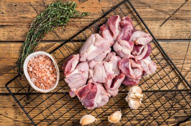 Fresh Raw chicken stomachs, gizzards on a grill ready for cooking with herbs. Wooden background. Top view.