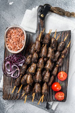 Chicken hearts grilled on skewers with herbs and spices. White background. Top view.