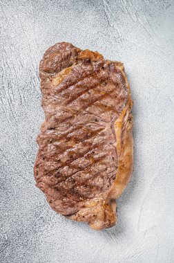 Grilled New York striploin beef meat steak. White background. Top view.