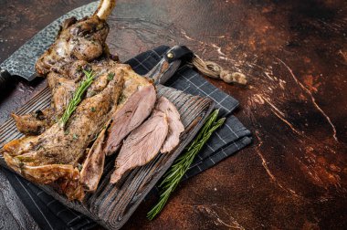 Slow Cooked grilled lamb mutton shoulder meat with herbs and spices on wooden board. Dark background. Top view. Copy space.