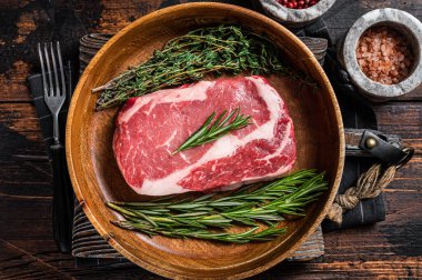 Biberiye ve kekik ile ahşap tabakta pirzola, biftek ve mermer et. Ahşap arka plan. Üst görünüm.