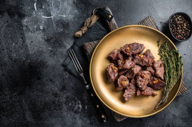 Dilimlenmiş ızgara sarımsaklı biftek ve kekik. Siyah arka plan. Üst Manzara. Boşluğu kopyala.