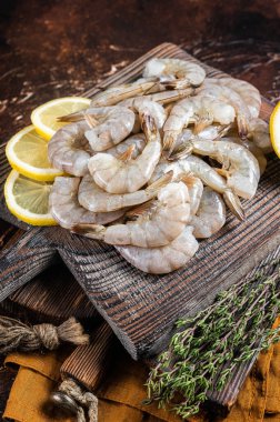 Çiğ kaplan beyaz karides ve otlar. Karanlık arka plan. Üst görünüm.