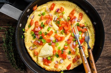 Sağlıklı kahvaltı yemekleri, iskelette sebzeli yumurtalı omlet. Ahşap arka plan. Üst görünüm.