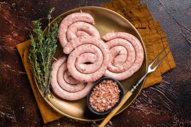 Çiğ domuz sosisi, pişmemiş sosis. Karanlık arka plan. Üst görünüm.