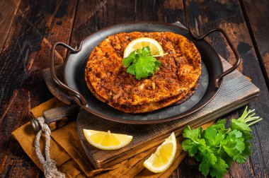 Traditional delicious Turkish foods lahmacun with mince lamb meat in steel tray. Wooden background. Top view.