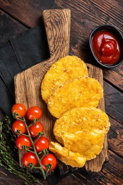 Hash brown potato, Potato Patties on a wooden board with ketchup. Wooden background. Top view.