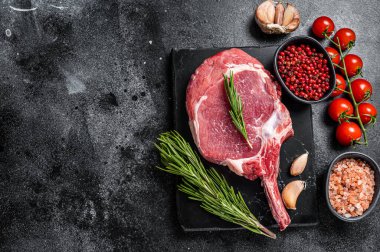 Çiğ kaburga ya da baharatlı Tomahawk bifteği pişirmek. Siyah arka plan. Üst Manzara. Boşluğu kopyala.