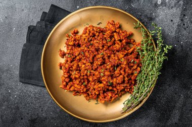 Bolognese sauce with ground beef, stewed with tomato sauce and spices. Black background. Top view.