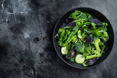 Ispanak, roka yaprağı, pazı ve sebzeli kuzu marulu taze salata karışımı. Siyah arka plan. Üst Manzara. Boşluğu kopyala.