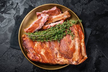 Grilled in BBQ Pork spare Ribs on steel plate with thyme. Black background. Top view.