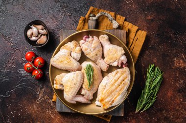 Tabakta kızarmış tavuk eti parçaları çeşitleri. Baget, göğüs filetosu, kanat, but. Karanlık arka plan. Üst görünüm.