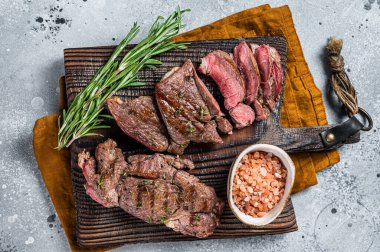 Roasted Mutton leg steaks, sliced lamb meat. Gray background. Top view.