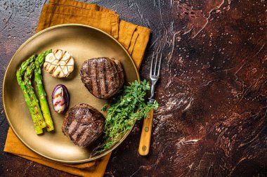 BBQ grilled Fillet Mignon Steak with asparagus, beef tenderloin meat. Dark background. Top view. Copy space.