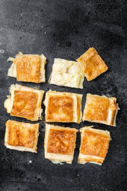 Turkish Su Boregi, Tabla borek or burek with cheese. Black background. Top view.