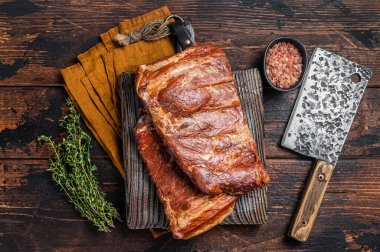 Meat restaurant kitchen. Smoked BBQ Pork Ribs on wooden cutting board. Wooden background. Top view.