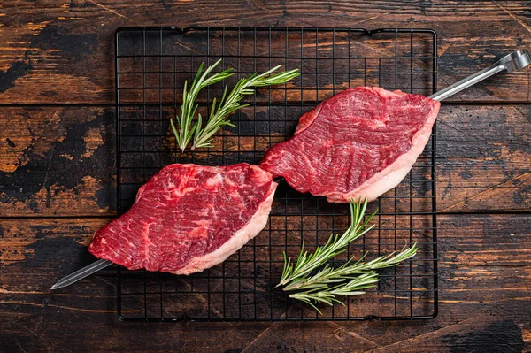 Ready for cooking raw picanha barbecue skewer. Wooden background. Top view.