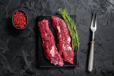 Çiğ Pala bifteği ya da otlarla kesilmiş yumuşak bir salkım. Siyah arka plan. Üst görünüm.