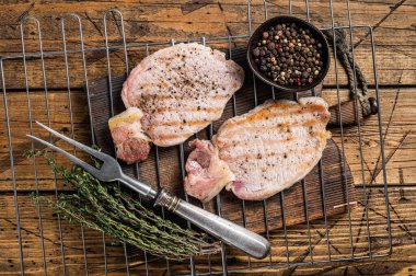 Grilled pork chop steaks on the grill, summer meat bbq. Wooden background. Top view.