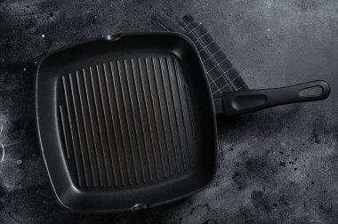 Kırsal havluyla yemek pişirmek için boş dökme demir tava. Siyah arka plan. Üst Manzara. Boşluğu kopyala.