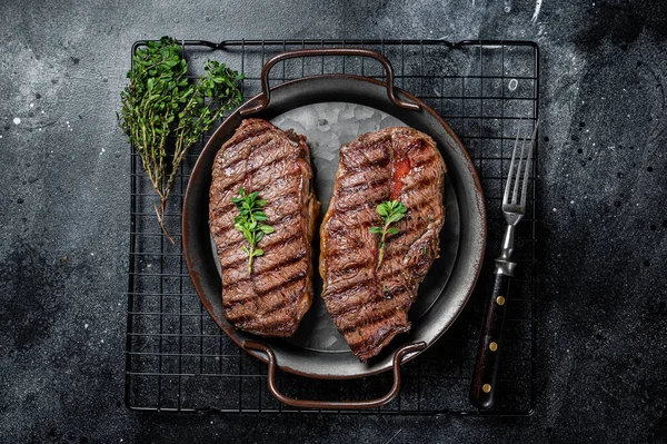 Grilled Top Blade or flat iron beef meat steaks. Black background. Top View.