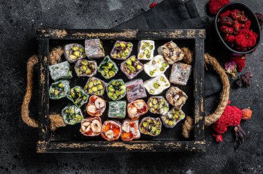 Türk Lokum 'u, fındıklı ve siyah çaylı oryantal tatlılar. Siyah arka plan. Üst görünüm.