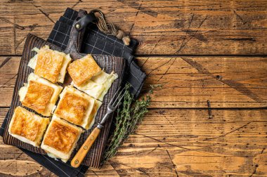 Delicious Turkish Tray pastry, Su boregi with cheese. Wooden background. Top view. Copy space.