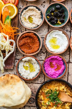 Geleneksel Türk Köy Kahvaltısı seramik masada hamur işleri, sebzeler, sebzeler, sebzeler, tabaklar, peynirler, kızarmış yumurtalar, reçeller ile. Üst görünüm.