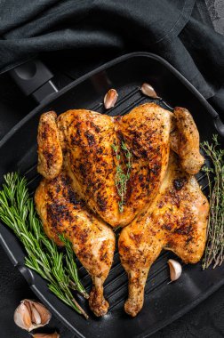 Barbekü serpilmiş ızgara tavada bütün tavuk. Siyah arka plan. Üst görünüm.