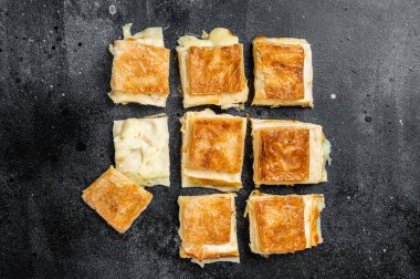 Turkish Su Boregi, Tabla borek or burek with cheese. Black background. Top view.