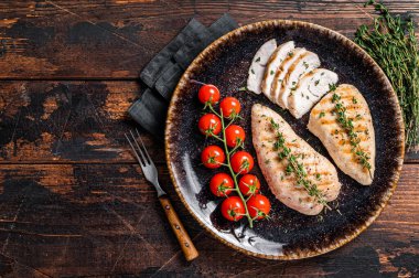 Protein yemeği - domatesli ızgara hindi göğsü bifteği. Ahşap arka plan. Üst Manzara. Boşluğu kopyala.