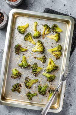 Fırın tepsisinde sarımsaklı brokolili lahana. Gri arka plan. Üst görünüm.