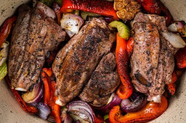 Braised slow cooked lamb shank in red wine sauce with vegetables in cooking pot. Black background. Top view. Copy space.