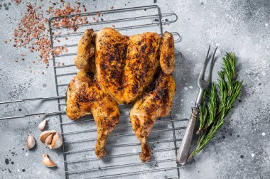 Geleneksel serpilmiş ızgarada ızgara tavuk. Gri arka plan. Üst görünüm.