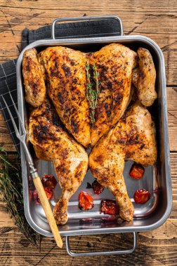 Ev yapımı tavuk rostosu, kekik ve fırın tabağı. Ahşap arka plan. Üst görünüm.