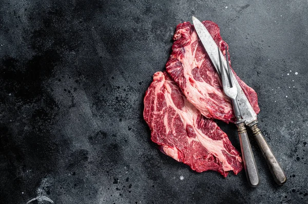 Fresh marbled meat Steaks with meat knife and fork table, beef rib eye steak. Black background. Top view. Copy space.