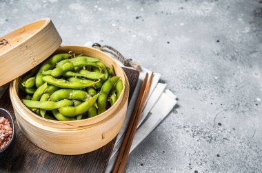 Steamed Edamame Beans with sea salt, soy beans. Gray background. Top view. Copy space.