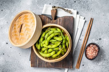 Steamed Edamame Beans with sea salt, soy beans. Gray background. Top view.
