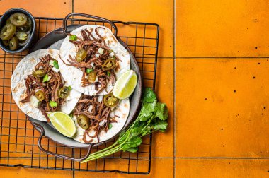 Spicy Beef Barbacoa Tacos with Cilantro and Onion. Orange background. Top view. Copy space.