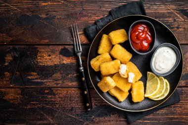 Fried Fish Sticks Fingers with sauce in a plate. Wooden background. Top view. Copy space.