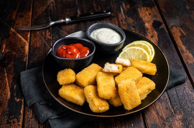 Fried Fish Sticks Fingers with sauce in a plate. Wooden background. Top view.