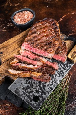 Barbecue dry aged wagyu entrecote rib eye beef steak. Dark background. Top view.