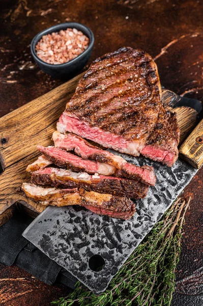 Barbecue dry aged wagyu entrecote rib eye beef steak. Dark background. Top view.